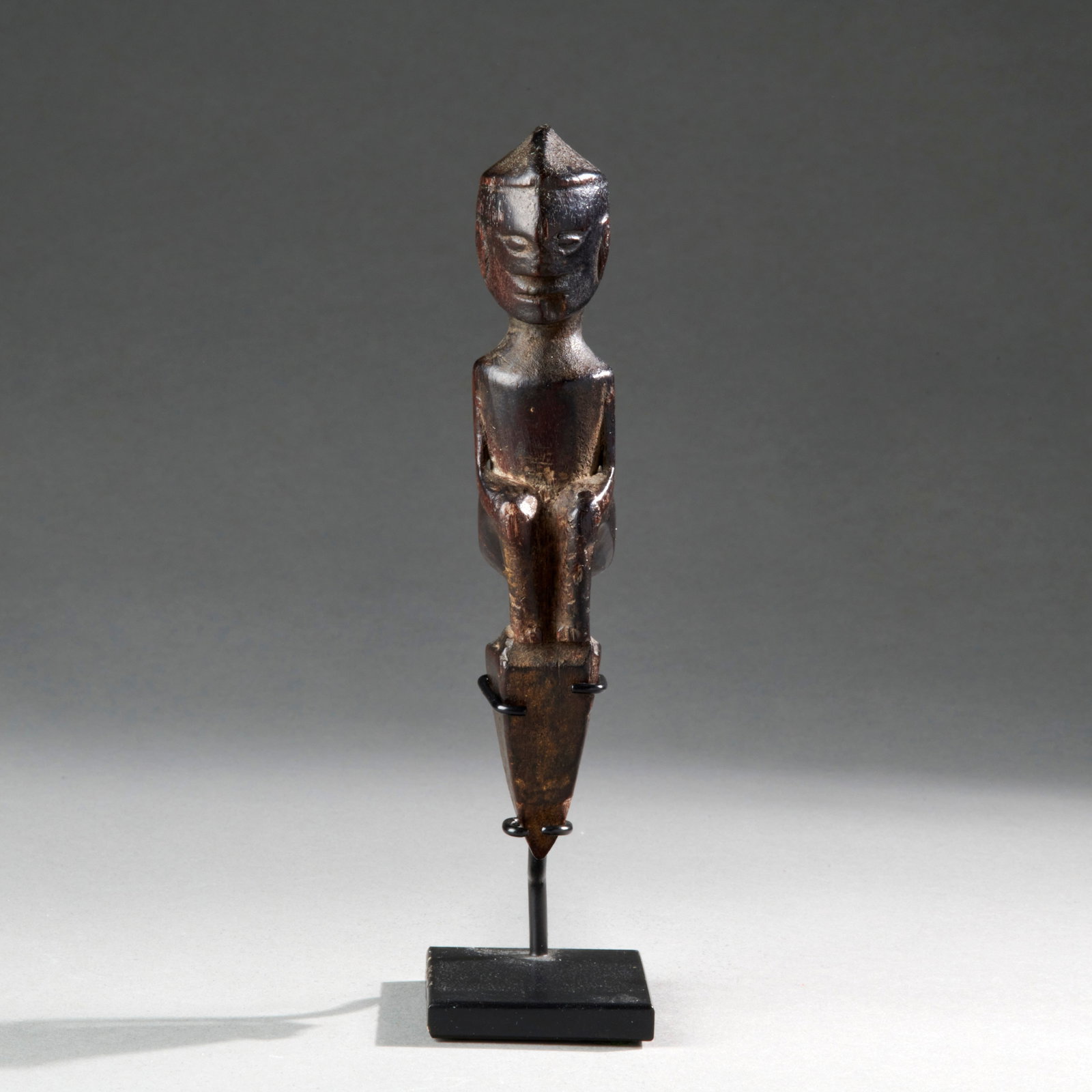 A Batak Shaman’s Lime Squeezer: Batak, Sumatra, Indonesia, late 19th Century, wood, with smooth, black patina, mounted on a metal base. Ht. 5 in. Provenance: Private collection, Boston, Massachusetts; Bruce Frank Primitive Art, New 