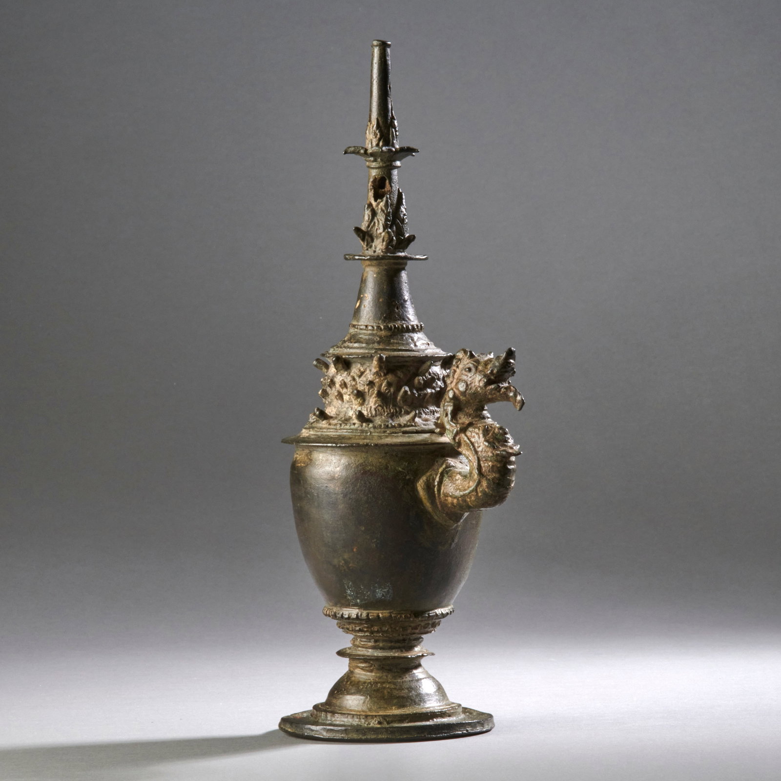 A Javanese Bronze Kundika: Java, Eastern Javanese period, circa 13th-14th century, the ritual holy-water vessel with high tapering neck and characteristic projecting spout in the form of a fanciful serpent (naga). As is custom,