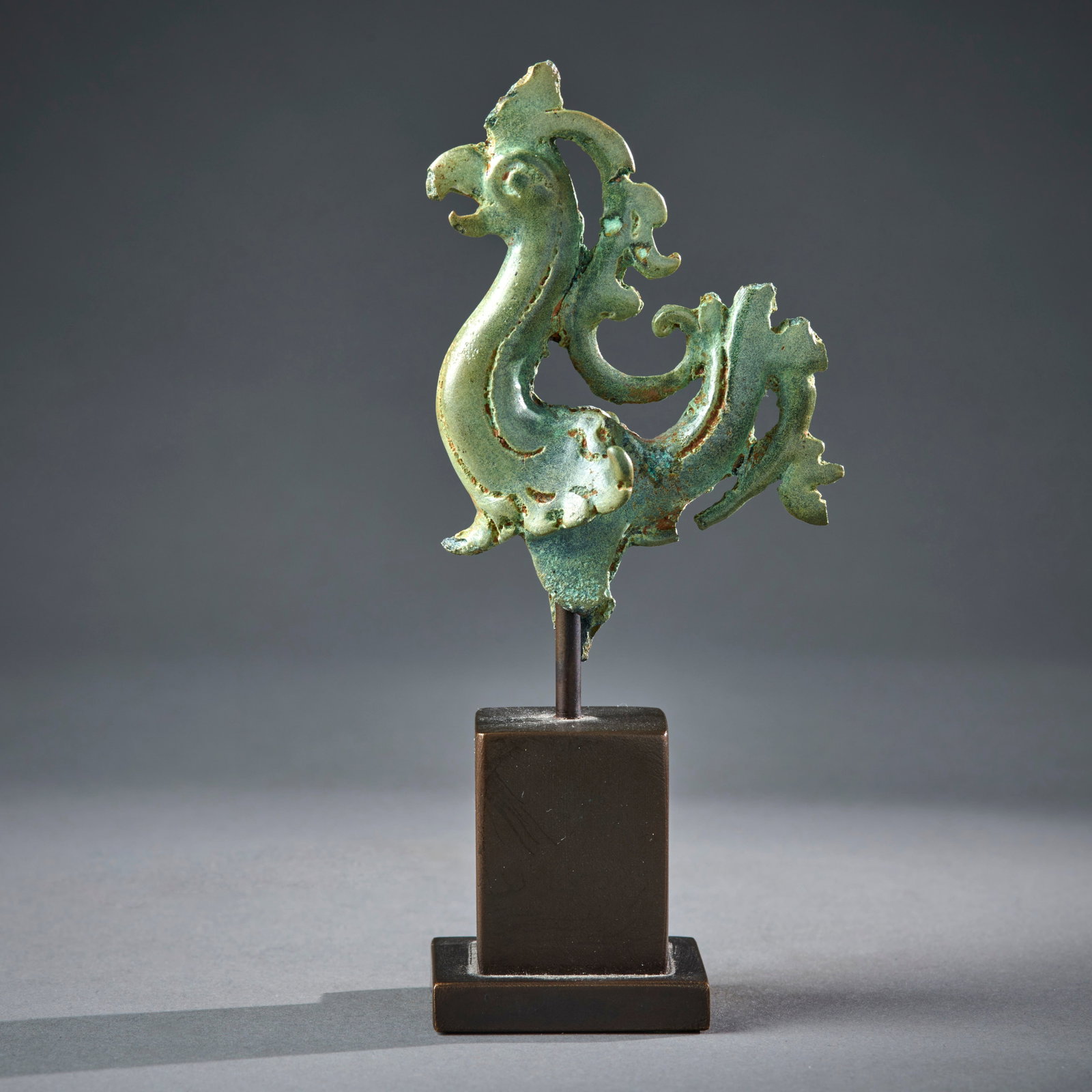 A Fine Javanese Bronze Bird Finial: Central Javanese period, 9th/10 century, a charming mythical bird, mounted on a custom bronze base, fine glossy green patina, Ht. 3 in. 7.7 cm, ht. with base 4 3/4 in. 12.2 cm. Losses as shown, otherw