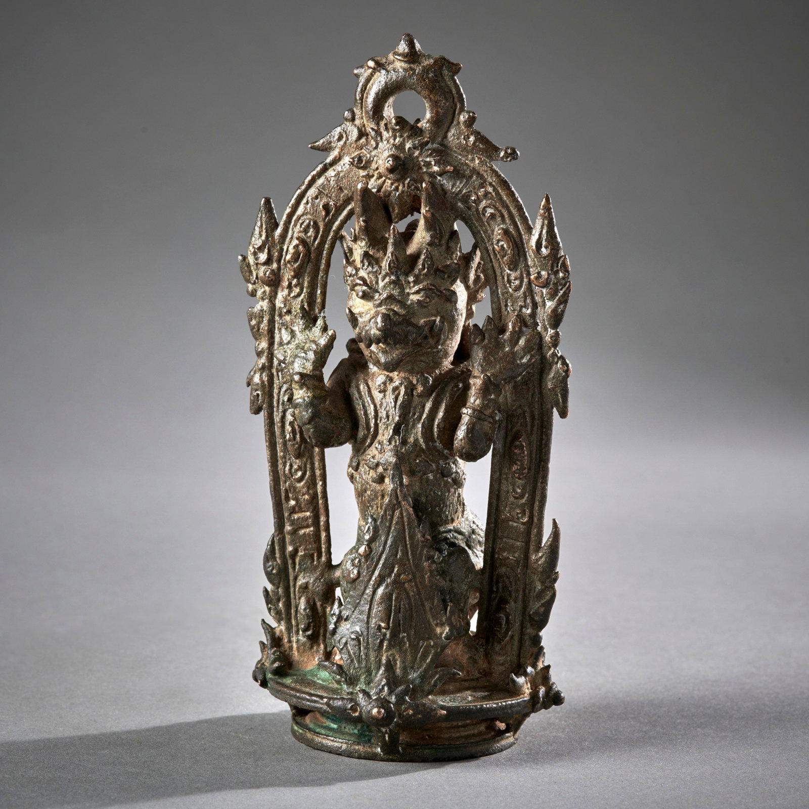 A Javanese Bronze Temple Bell Finial: Eastern Javanese period, circa 13th century, an ornately detailed depiction of a rampant Singha lion, framed with floral elements. In good condition as shown. Ht. 5 1/2 in. 14 cm. Provenance: An old N