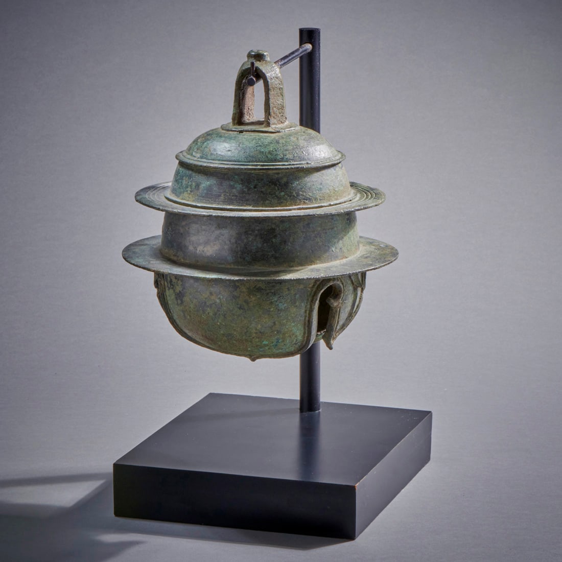 A Khmer Elephant Bell: Cambodia or Thailand, circa 12th-13th century, an elegant, large example, on custom stand. Fine condition. Ht. without stand 8 1/2, wd. 7 3/4 in.Provenance: Alsdorf collection, Chicago, from an online