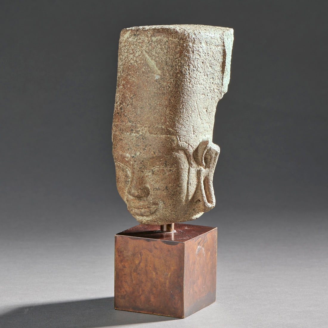 A Brown Sandstone Head Of Vishnu: Cambodia, Pre-Khmer, early Prasat Andet period, early 7th century, a buff sandstone head of Vishnu wearing a high cylindrical crown, with custom base, with some losses. Ht. 4 1/2, 6 ½ in. with