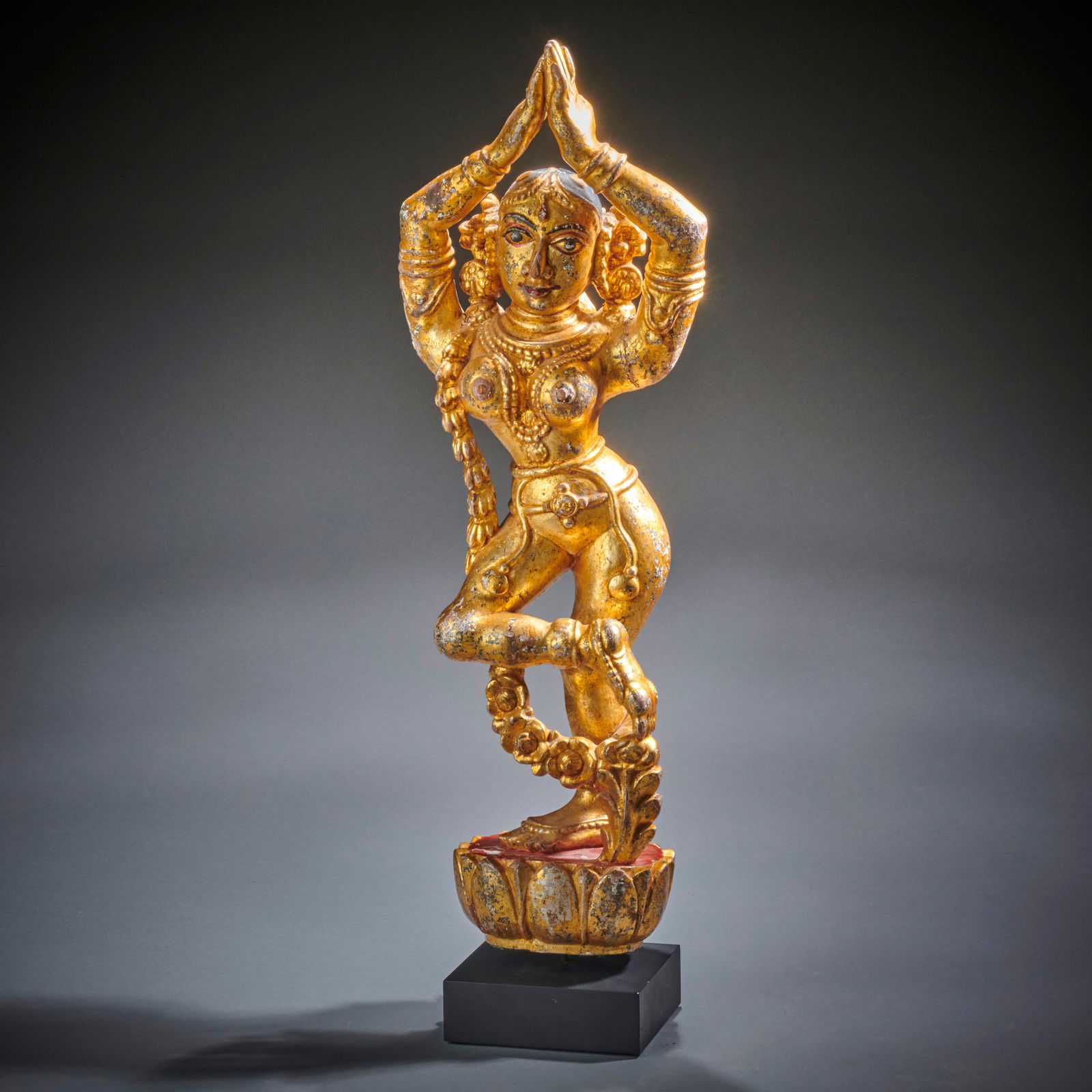A Gilt Wood Indian Yakshi: Circa 19th century, the voluptuous celestial dancer in lively pose on half lotus. Custom metal base. Good condition with minor defects. Ht. 23 5/8 in. with stand. Shipping within the continental U.S.