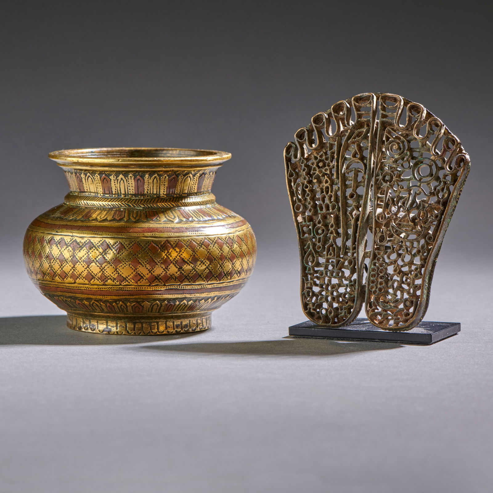 Two Indian Bronze Objects: Circa 18th/early 19th century, a small cast and spun jar, decorated with leaf and diamond patterns embellished with copper accents (‘Ganja Jumna’ technique), along with a very fine body stamp in t