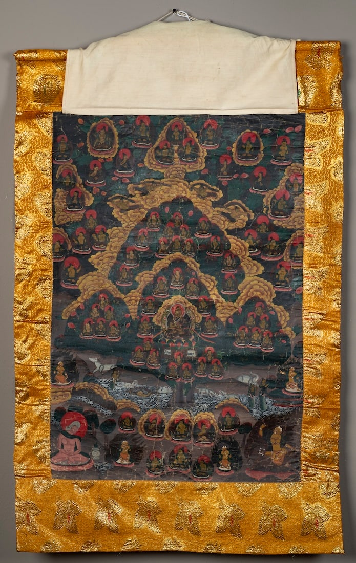 A Tibetan Thangka painting: 19th century, painted on cotton cloth, depicting scenes of Buddhist deities, with a later gold silk border and cloth protecting cover, with wood pole at the top. Size of painting 29 1/4 x 20 1/4, tota