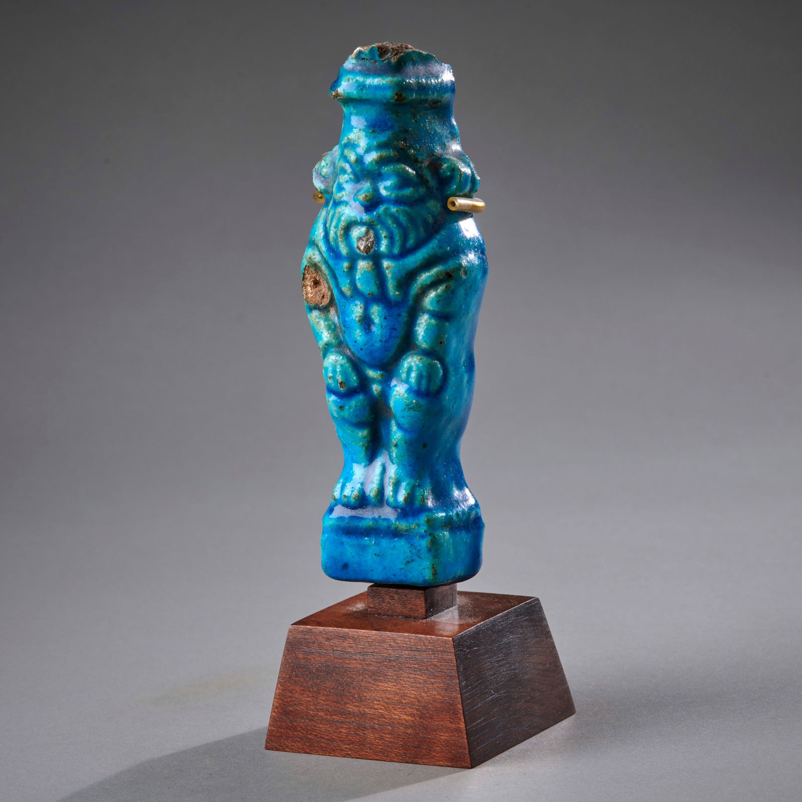 A large Egyptian Faience Bes Figure: Late Period, circa 500-300 B.C., an impressive faience figure of the dwarf God, in classic pose, with vibrant blue glaze, lacking most of the feather headdress, glaze chip to upper right arm, otherwis