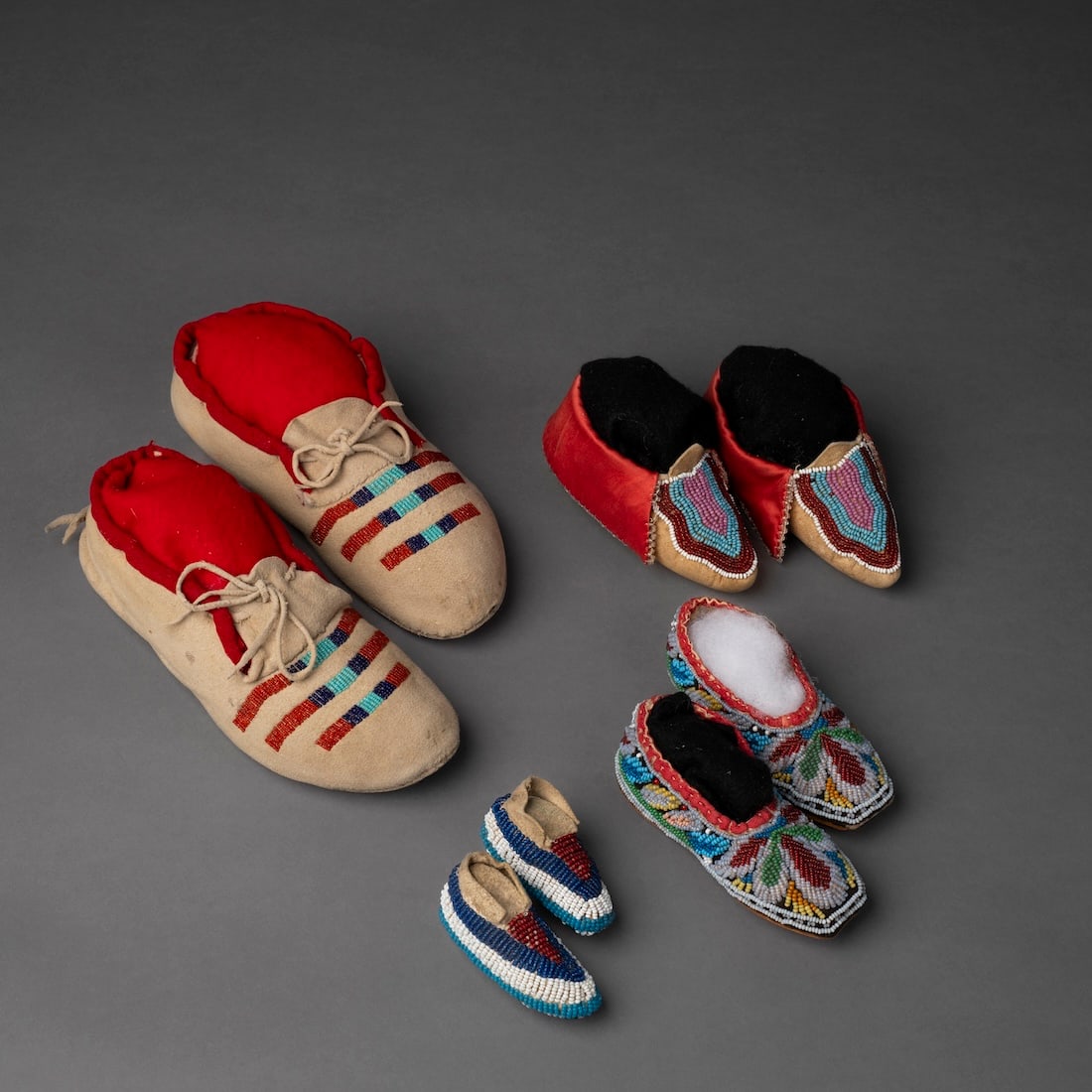 A collection of small Plains beaded moccasins: A soft hide pair with three beaded bands on the vamps, a pair of Delawre and Iroquois infants moccasins with beaded vamps, and a miniature Plains pair fully beaded. Lg. 8, 5, 4 3/4, and 2 3/4 in.