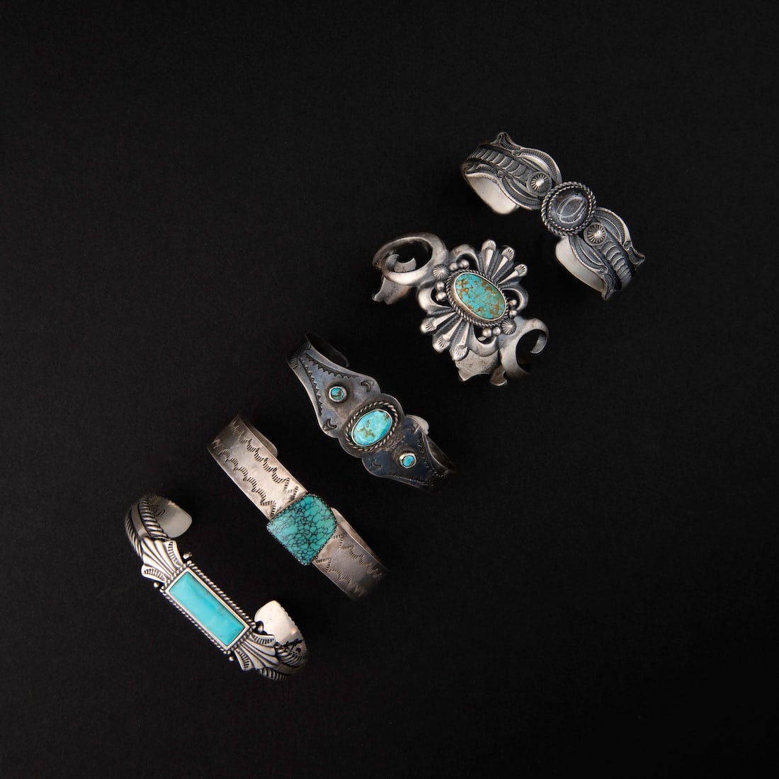 Five Navajo (Diné) silver and turquoise bracelets: Five silver cuff bracelets each with a turquoise setting, one marked "LE Billah." Inner circumference (including gap) 6 1/2, gap 1 1/4, inner circumference (including gap) 6 1/2, gap 1, inner circumfe
