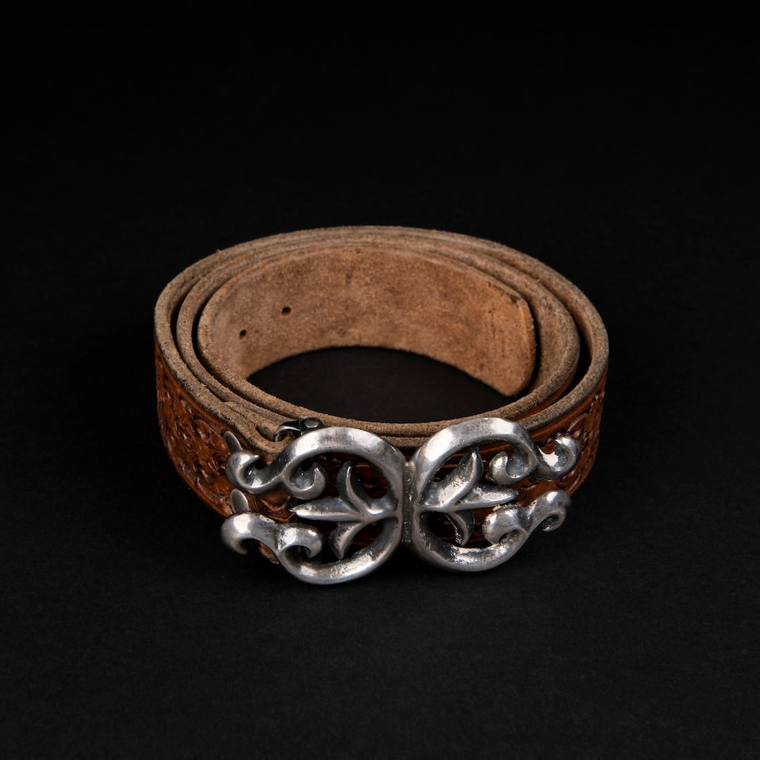 A Navajo (Diné) silver sandcast buckle and belt: The silver sandcast buckle, with a tooled leather belt. Lg. 39 1/2 in.