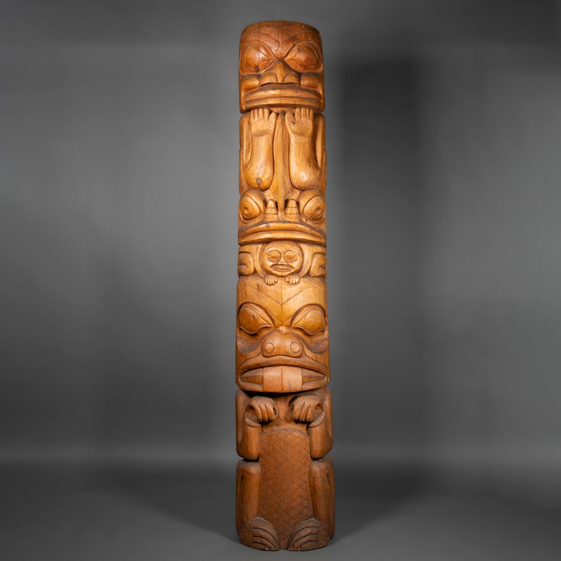 A contemporary Northwest Coast totem pole: The large wood totem pole with three clan animals and a human carved, the base a beaver, signed verso, “Bill Bouchard 88006.” Ht. 82 ½, wd. 13 in.
