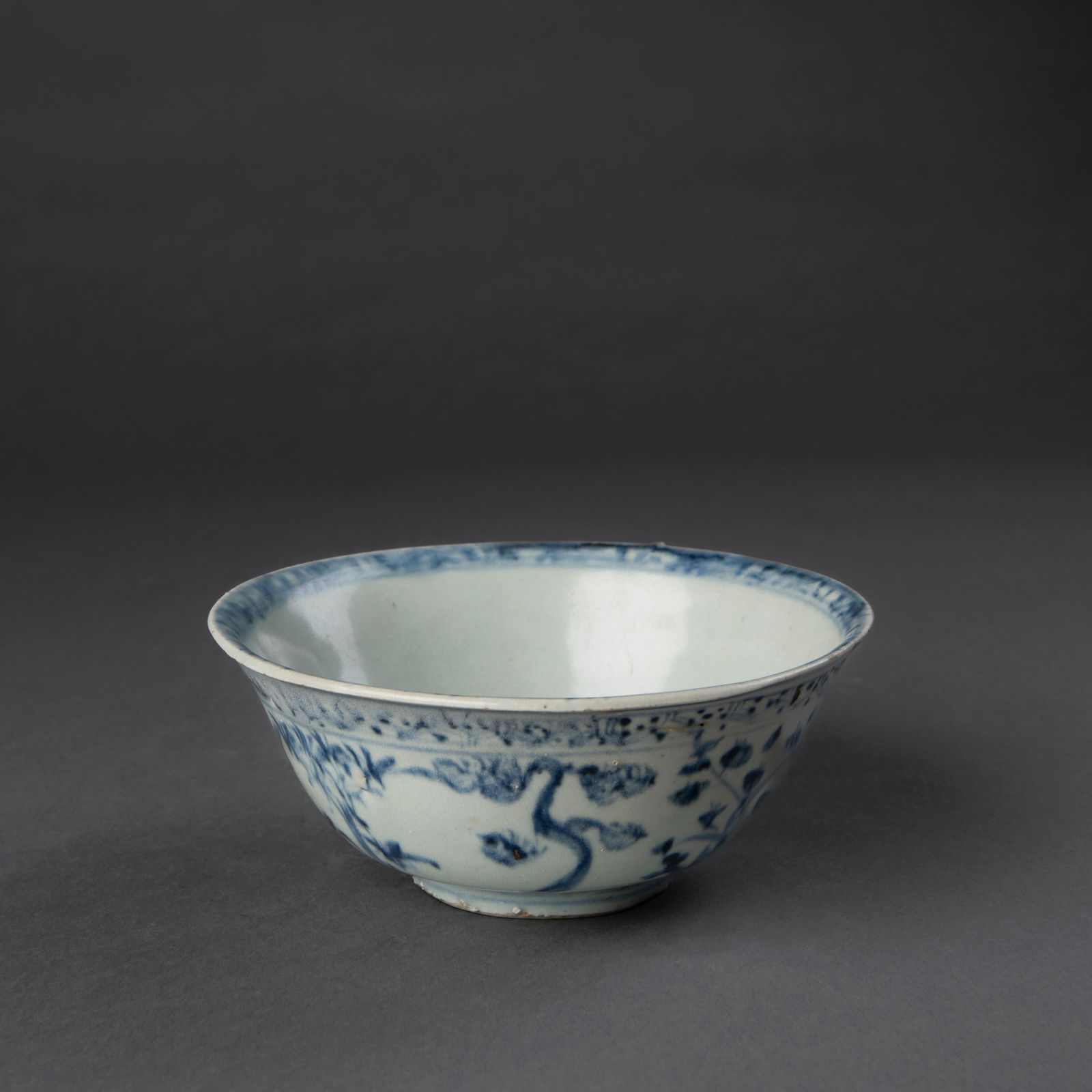 A Ming Chinese export Blue and White bowl: Ming, 15th century, standing on a low round foot, decorated on the exterior, around the inner rim, and on the inner bottom in blue landscape and tree designs, unmarked, comes with a padded box. Ht. 2