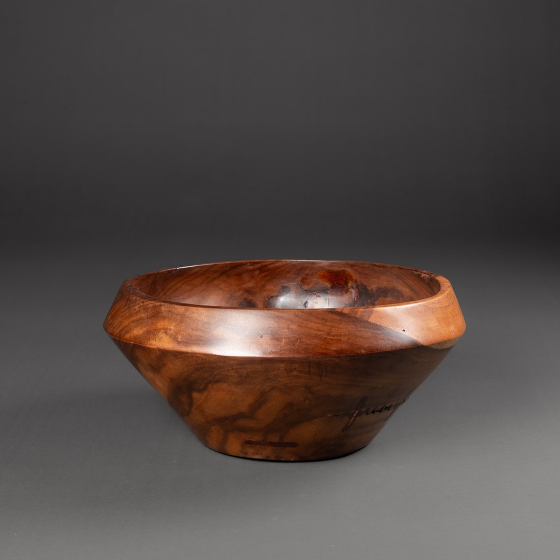 A Hawaiian bowl from Maui: Umeke kepakepa, 19th century, probably Kou wood bowl from Maui, the flat bottom tapering outwards with a horizontal rib below the inward tapering rim; multiple indigenous zigzag wood patch (kepa) and