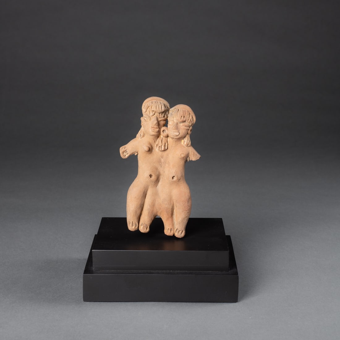 A Pre-Columbian figural group: Tlatilco, Central Mexico, Middle Preclassic, circa 1150-550 B.C., depicting Siamese twins joined at the body. Ht. 5, wd. 2 3/4 in, mounted on a custom stand. Provenance: Private collection,