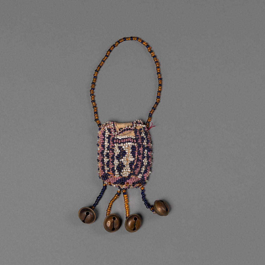 A small Apache beaded pouch: Circa 1870's, translucent gold and navy bead strap, white, pink and blue beaded body, the verso white and pink and pink and blue crosses with edge beading in pink, blue and white, with four