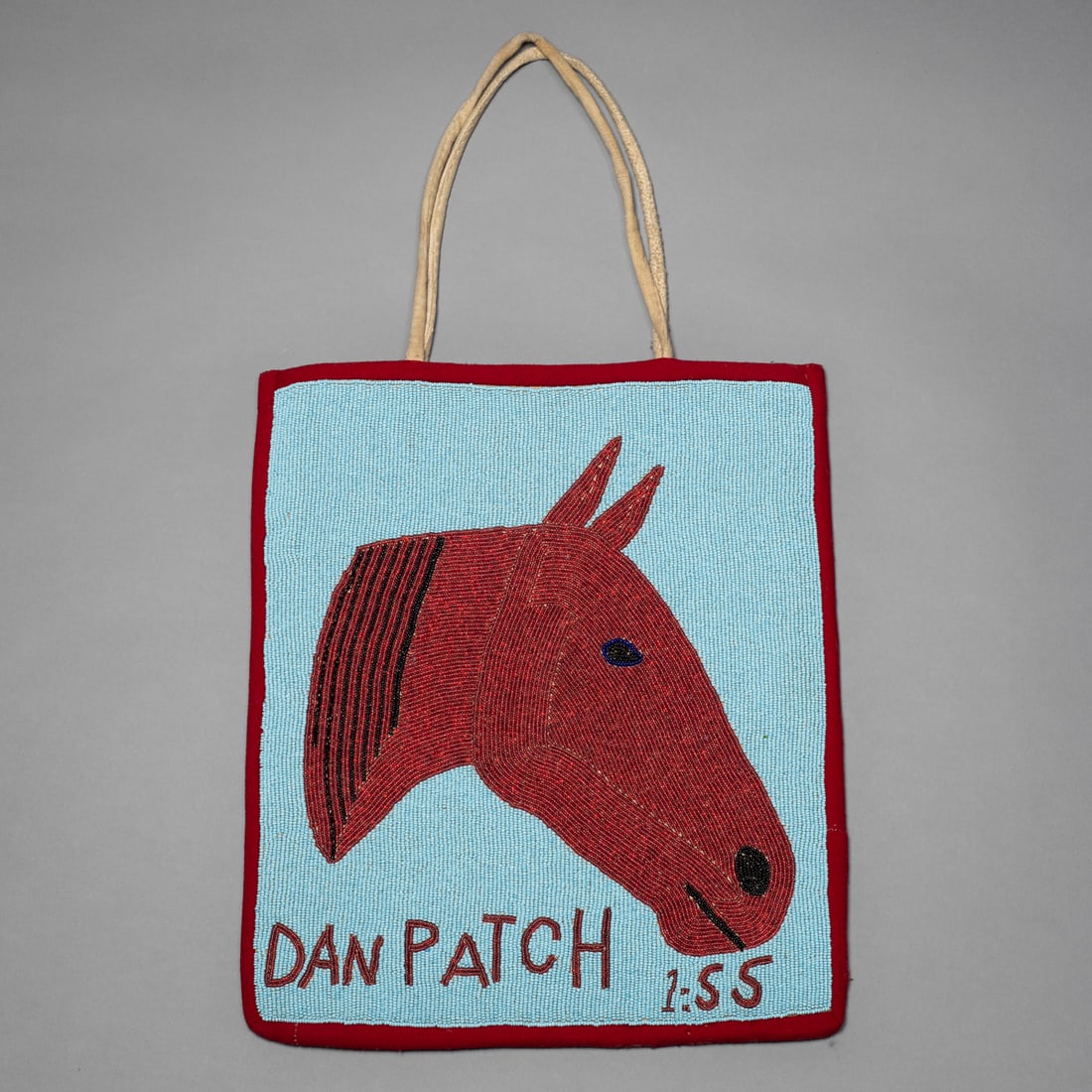 A Plateau beaded Dan Patch flat bag: A striking Plateau beaded horse-design flat bag, featuring a finely executed image of Dan Patch, the famed American pacer who set a world record of 1:55 in 1906. The horse’s head, rendered in red