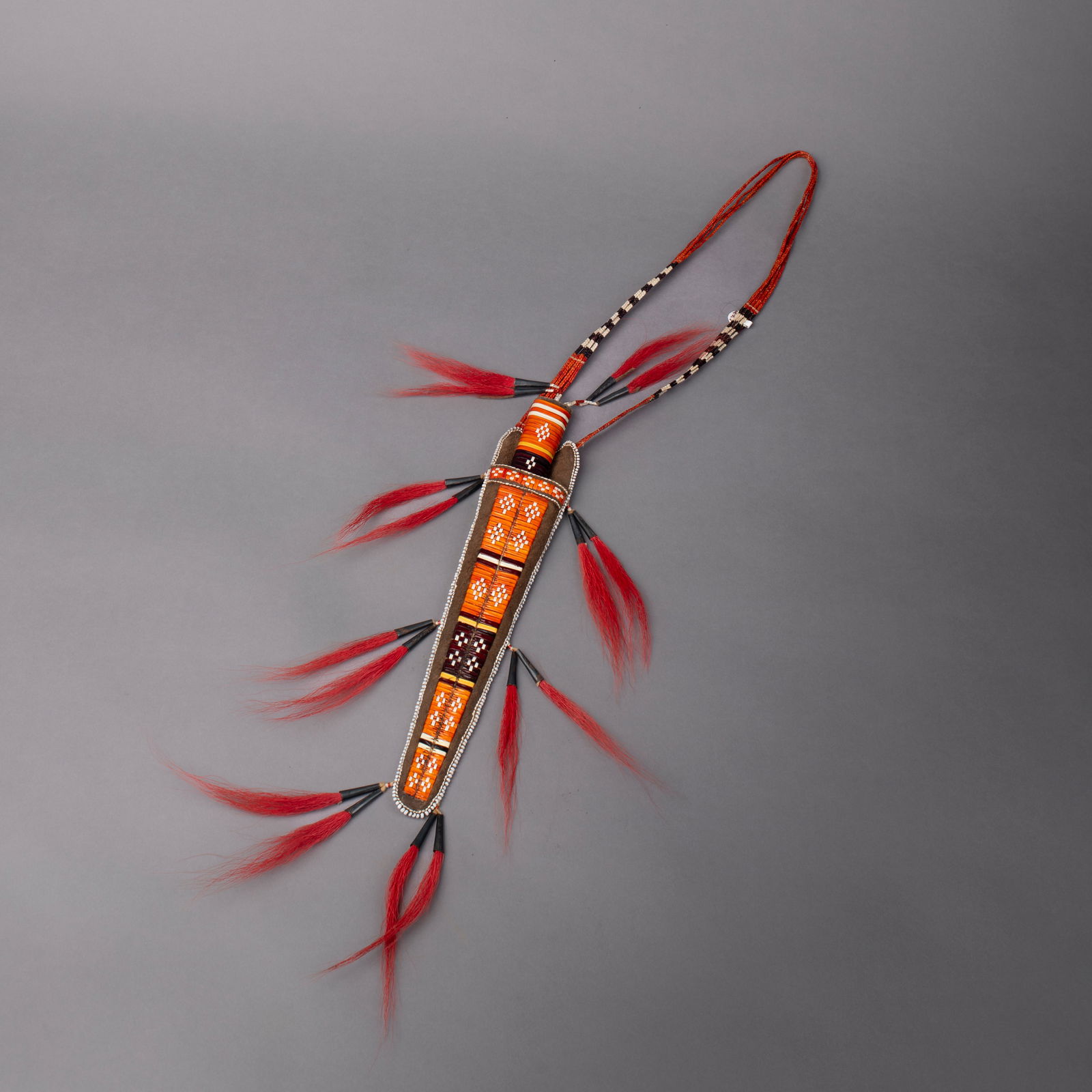 A Brent Boyd beaded and quilled knife and sheath: Brent Boyd, Oshawa, Ontario, Canada, 1990’s, the hide sheath with multicolored quillwork and bead decoration, with a quill strap, and horse hair and tin cone attachments, signed, “Boyd,”