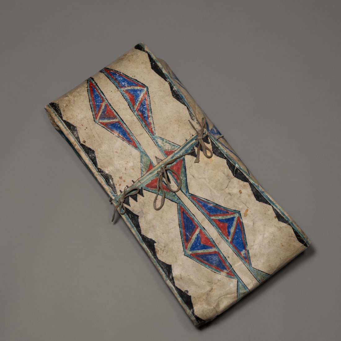 A Blackfoot parfleche envelope: Late 19th century, constructed from buffalo hide, the front painted with traditional geometric designs. Ht. 27, wd. 13 1/2 in. Provenance: The James Pavitt and Carolyn Stettner collection, Santa Fe,