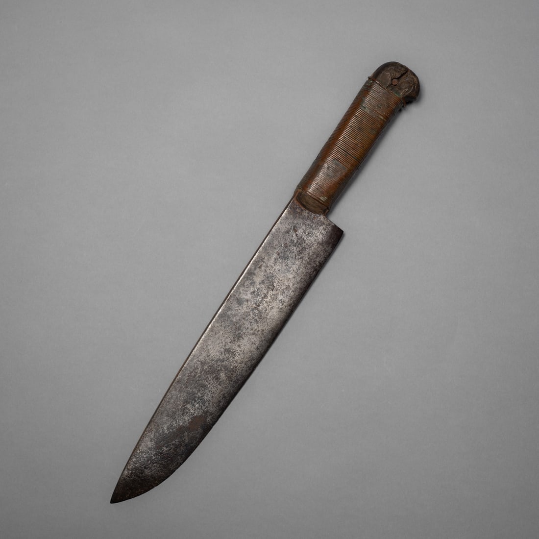 A Western Great Lakes, Plains Indian camp knife: Handcrafted, traditional camp knife with a long, heavy blacksmith forged trade blade attached to a wooden handle wrapped with copper wire. Lg. 15 in.