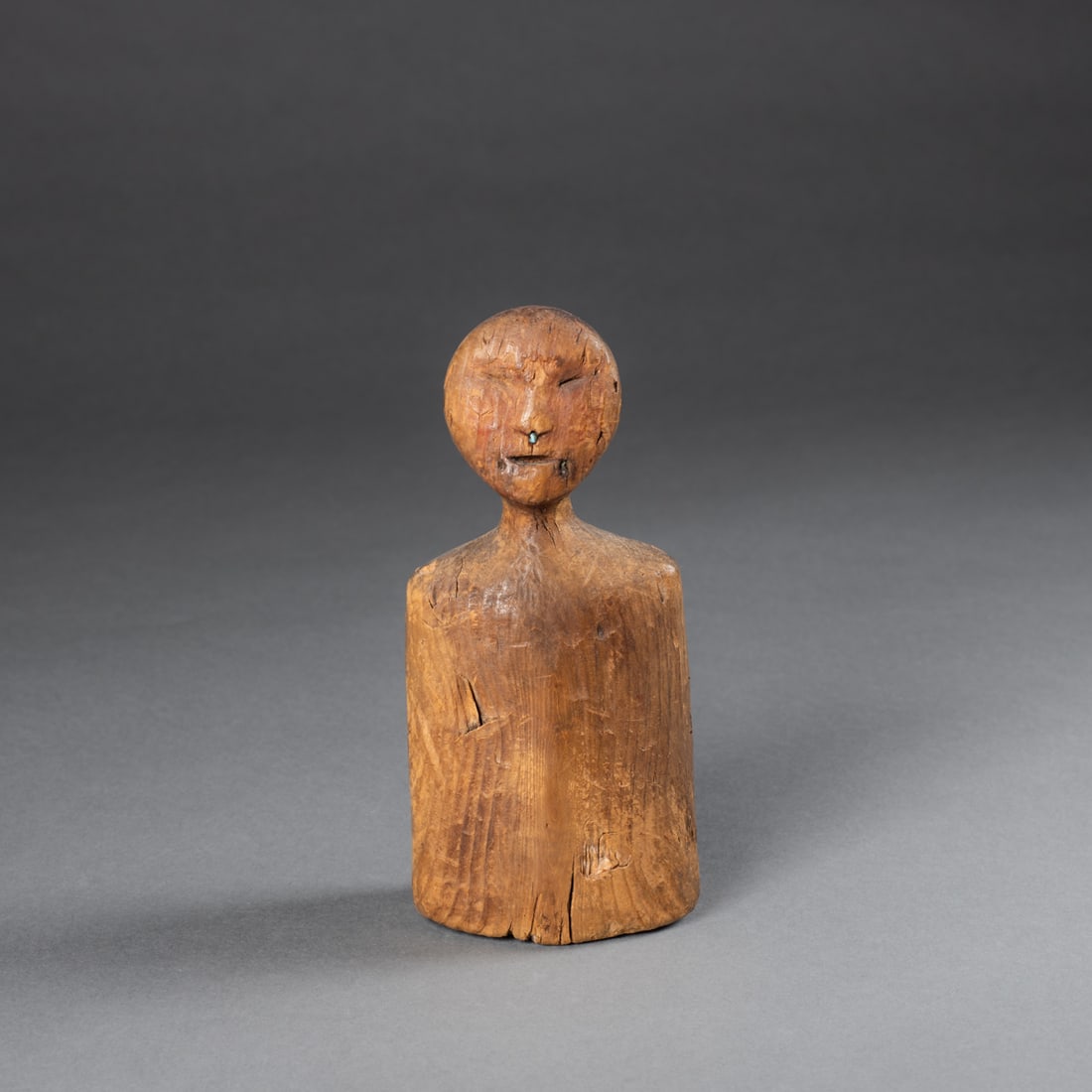 An Eskimo wood torso: Alaska, 19th century, the wood torso, possibly a canoe figure with inlay stone in ears and nose. Ht. 6 1/4, wd. 2 5/8 in. Provenance: Private collection, Albuquerque, NM.
