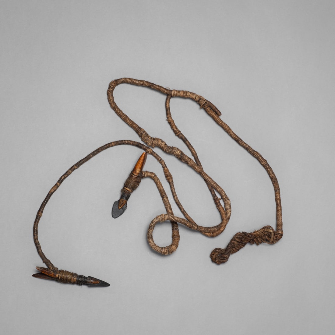 An Eskimo line with two harpoon points: Composed of twisted sinew cord with two attached harpoon points, each bound with fine sinew and exhibiting rich surface patina. Lg. 36 in.