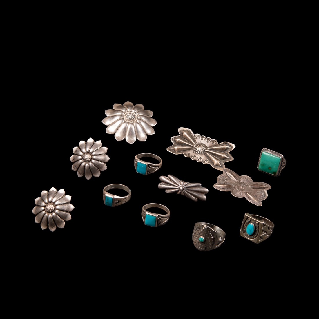 A collection of Navajo (Diné) jewelry: Six silver and turquoise rings, three silver stamp decorated pins and a cuff link and bolo set, four of the rings marked "Sterling." Ring sizes 9.56.75, 9.5, 8, 7.5, and 8. Pin sizes 2 x 1, 1 1/2 x