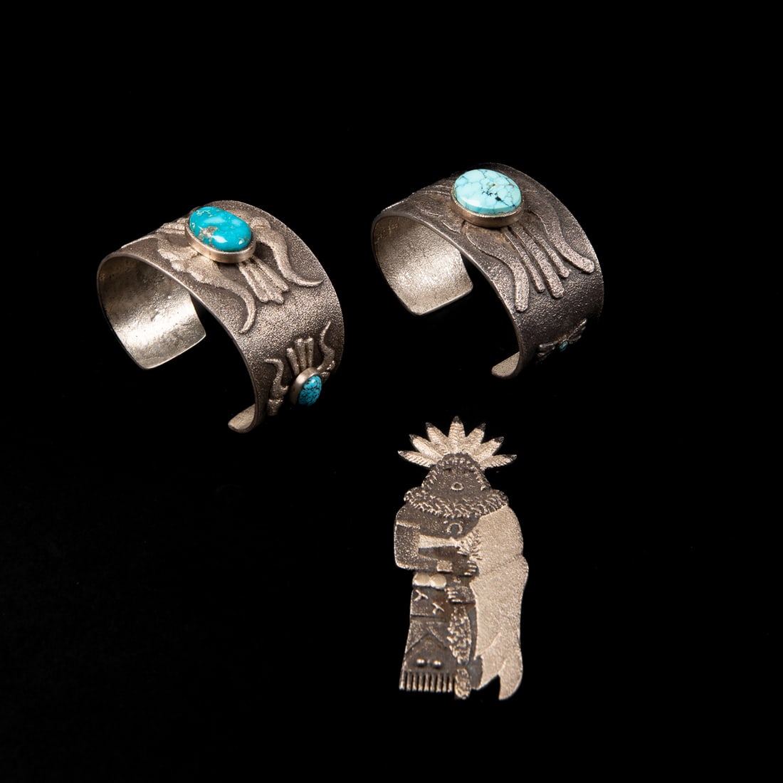 Two Lee Begay tufa bracelets and pendant: Two silver tufa cast bracelets, one with a single turquoise setting in a raised bezel and one with three settings, marked "Lee B '22 " and "Lee B '19," with a tufa cast pendant marked "Lee B '22."