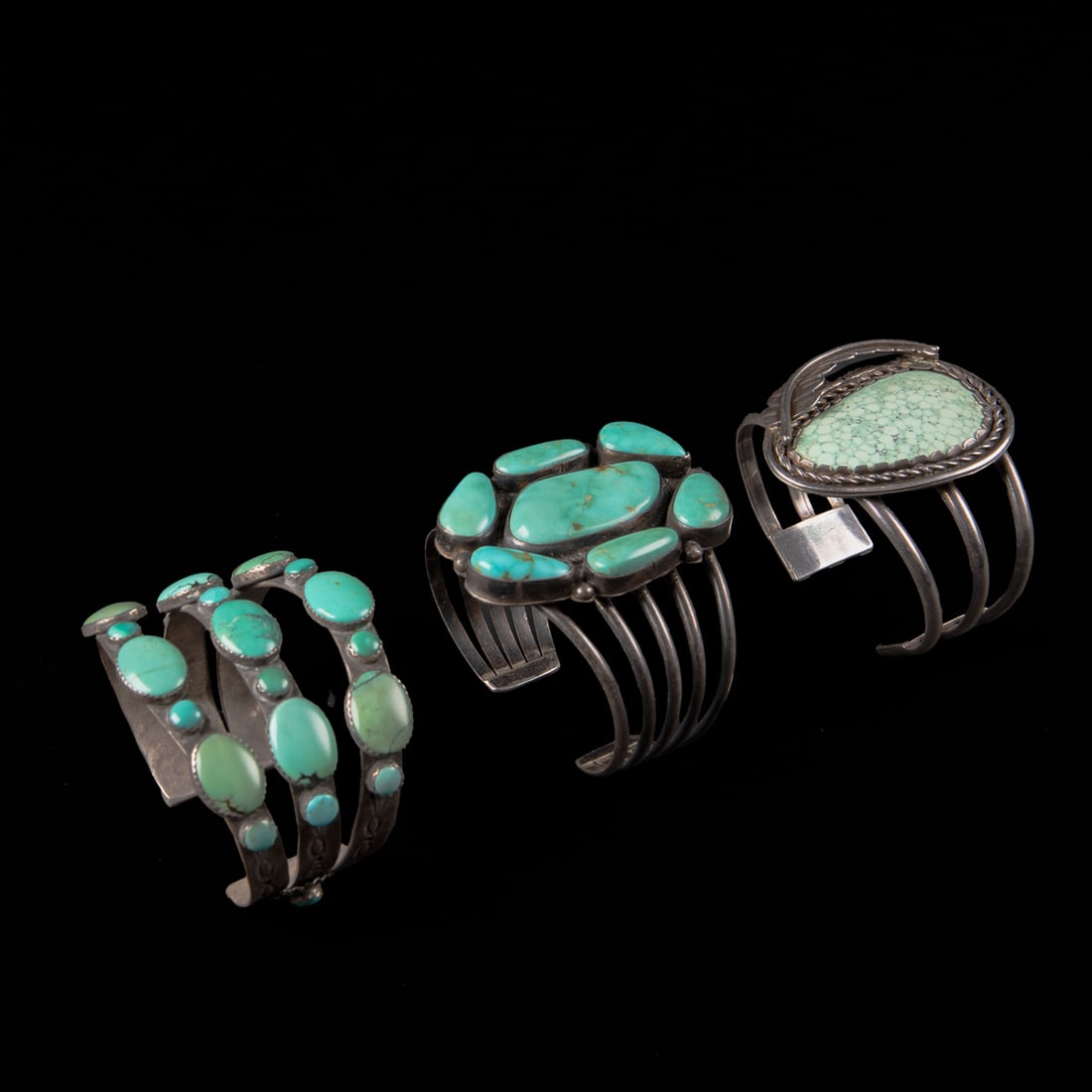 Three vintage Southwest silver and turquoise bracelets: A five-wire cuff with a cluster of seven turquoise settings, marked "BB" and "Sterling," a three-wire cuff with a single turquoise setting, and a three-row cuff each with seven turquoise settings, mar