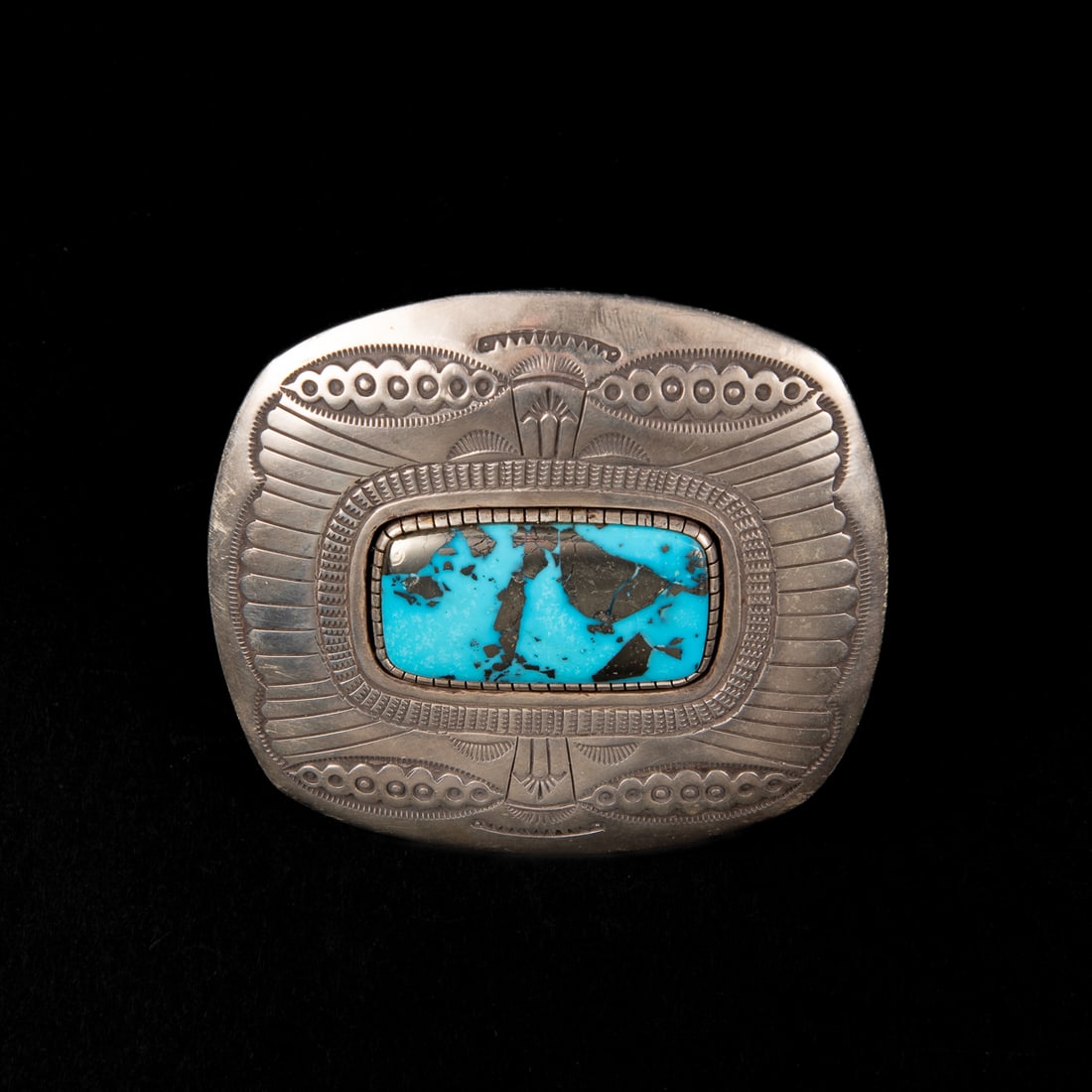 A Larry Martinez silver and turquoise ring: The large Sterling silver ring with stamp and chisel decoration, with a large rectangular Morenci turquoise setting, signed "Larry Martinez," and marked "Sterling." Ring size adjustable 9, top size 3
