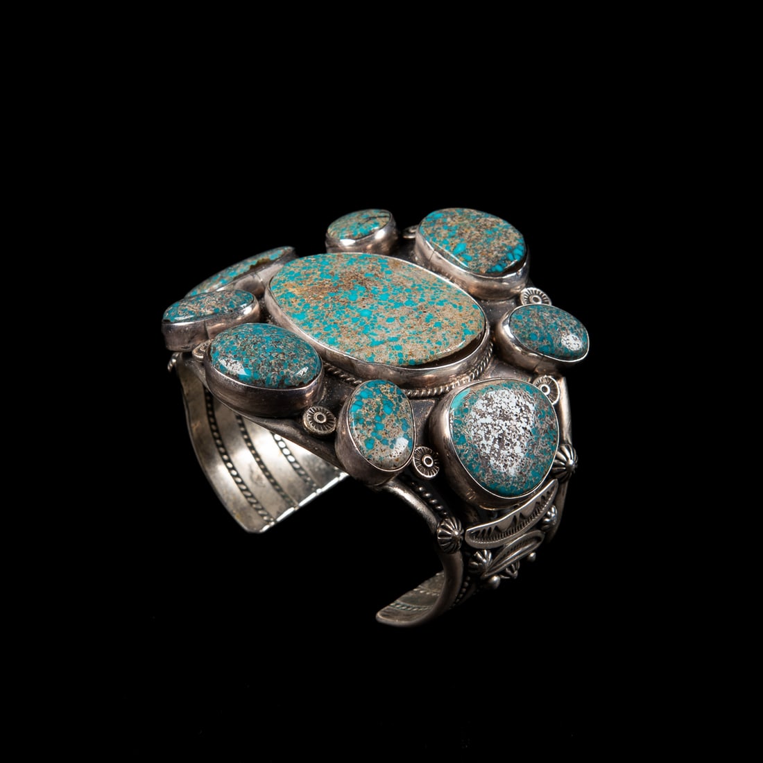 An Ella Linkin silver and turquoise cuff bracelet: The wide five-wire Sterling silver cuff with large turquoise cluster of nine stones, signed "E M Linkin," and marked "Sterling." Total interior circumference (including gap) 6 5/8, wd. 2 1/2, gap 1