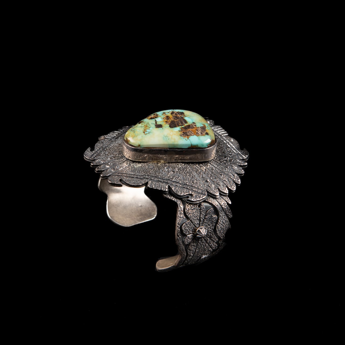 A Marco Begay silver and turquoise cuff bracelet: The Sterling silver cuff with large silver plaque and large turquoise setting, marked "MB Sterling." Total interior circumference (including gap) 6 3/4, wd. 2 3/8, gap 1 in. Gross weight