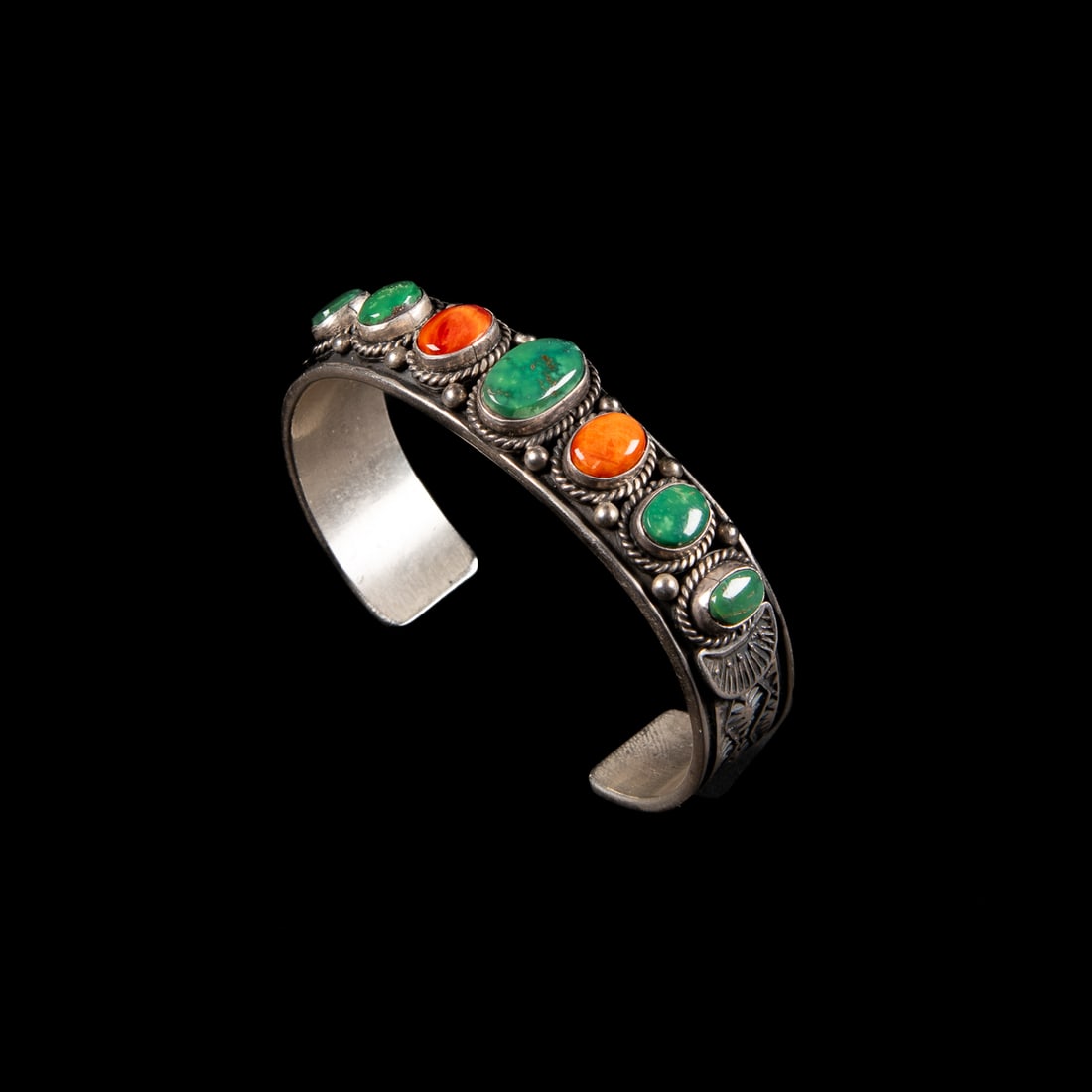 A Sunshine Reeves silver and turquoise cuff bracelet: The Sterling silver cuff decorated with stamp, ball and ropework, with turquoise and spiny oyster settings, signed "Sunshine Reeves," and "Sterling." Total interior circumference (including gap) 6