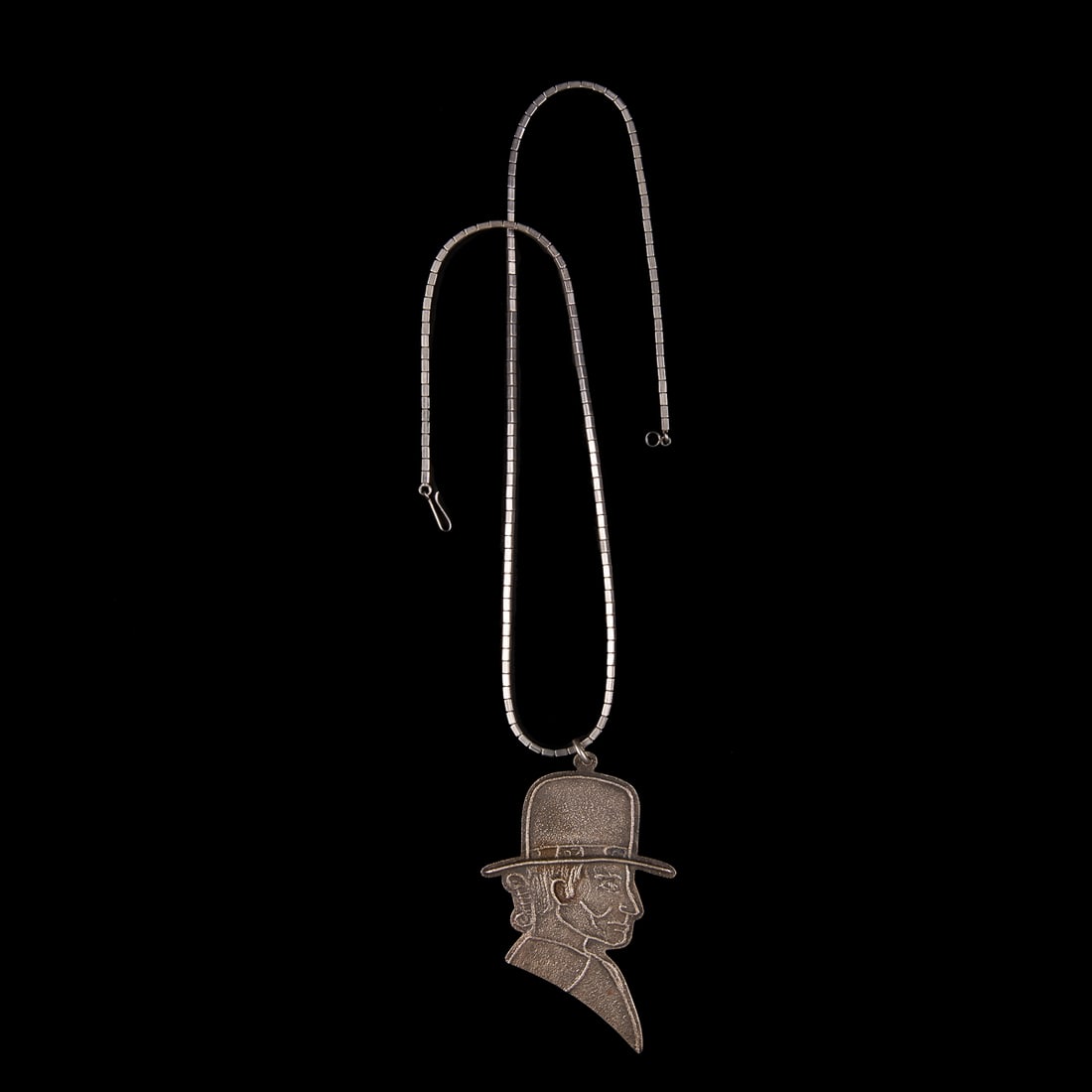 A Robert Whitehair Begay necklace with pendant: The silver necklace with a tufa cast silver pendant of a Native American wearing a hat, marked "RWB," verso. Lg. of necklace 24, pendant 3 1/2 x 2 1/4 in. Gross weight approximately 65g.