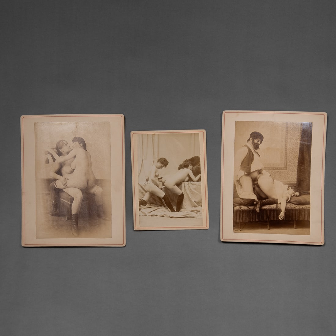 Three albumen printed photographs of an erotic nature: 19th century, Lot of three photographs of explicit sexual scenes, two involving two women and the third with a man and woman. Each photograph comes in a hard plastic case. Each 9 ½ x 7 in.
