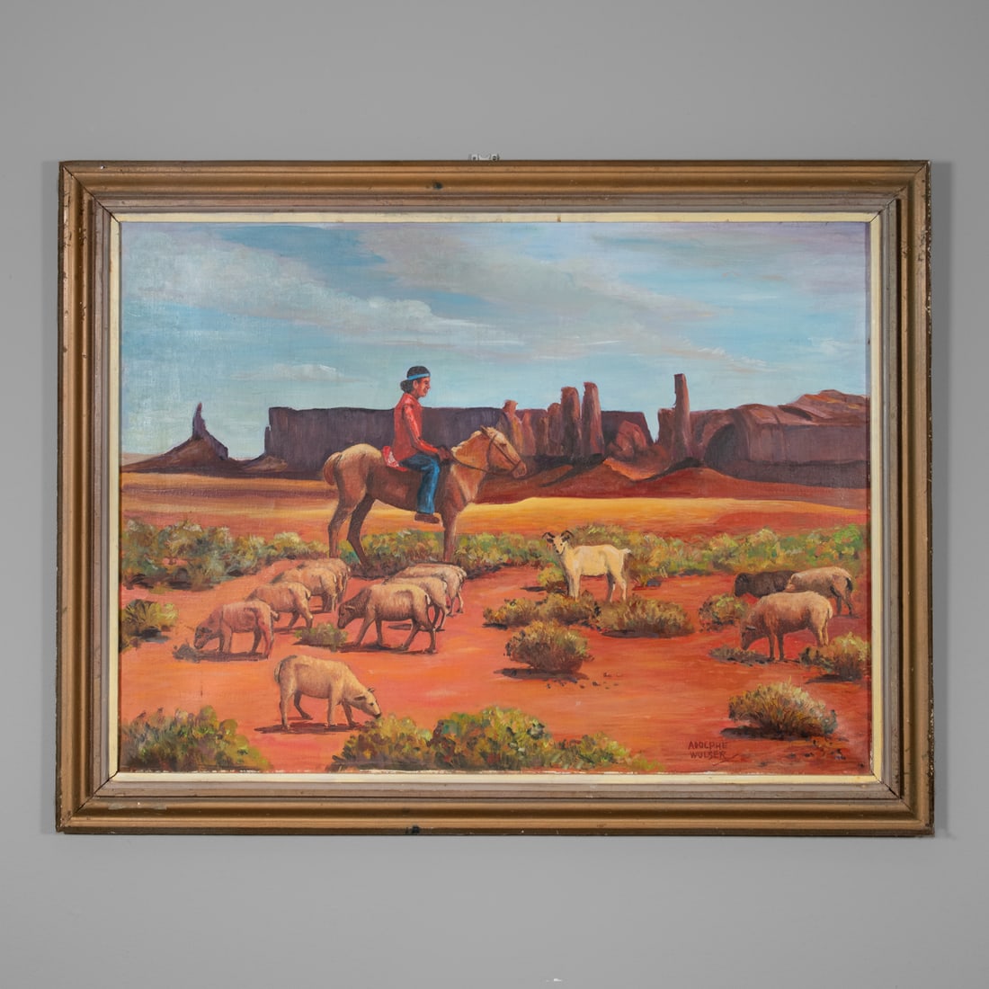 An Adolphe Wulser painting: Adolphe Wulser 1900-1984, oil on canvas, a vivid Southwestern landscape by Adolphe Wulser, depicting a lone mounted Navajo herder guiding his flock across the ochre desert plain beneath the towering