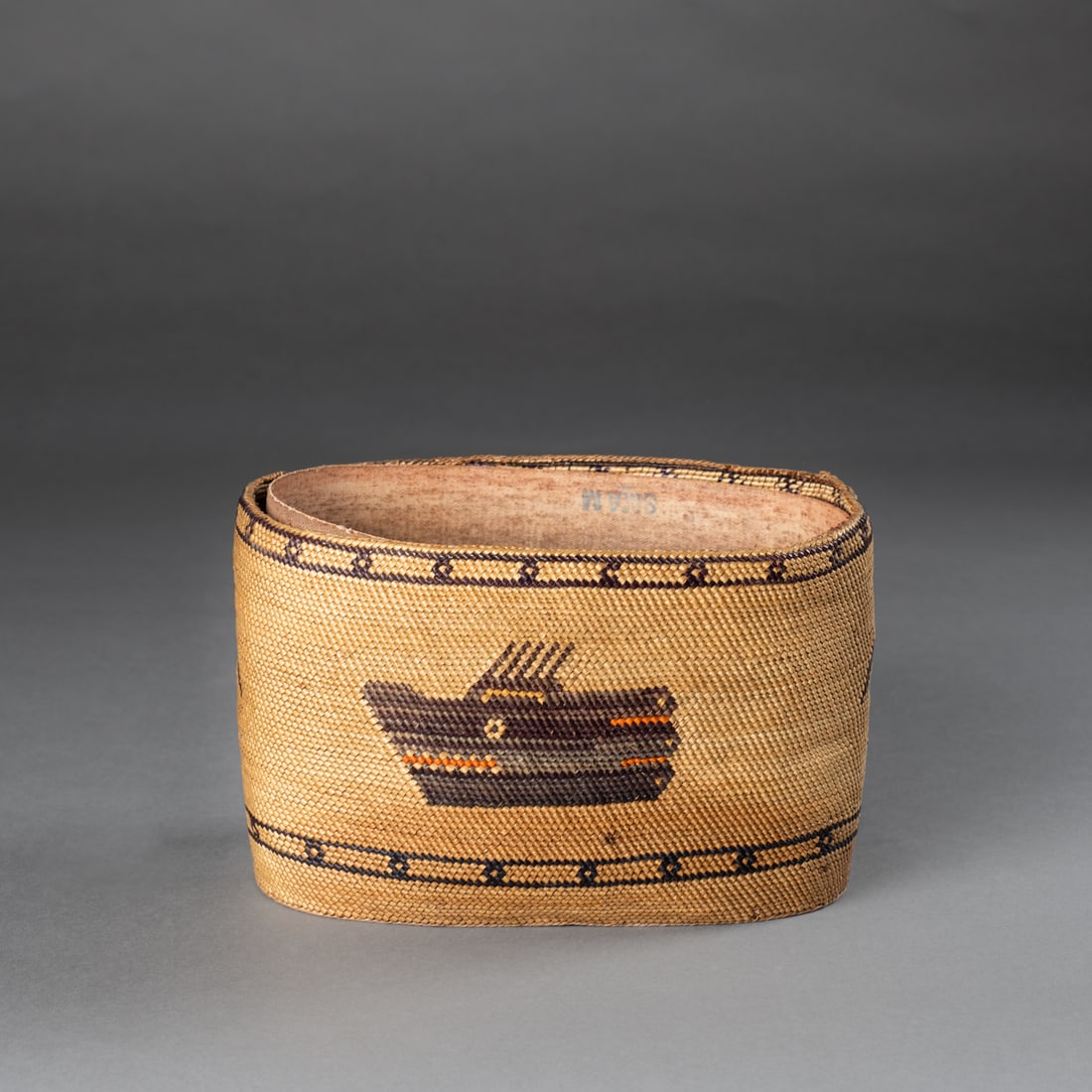 A Northwest Coast basket: Tlingit, late 19th century, the finely woven basket with a frieze of birds and sea creatures below the rim, the interior supported with a band of heavy canvas. Ht. 4 1/2, lg. 7 1/2, wd. 6 in.
