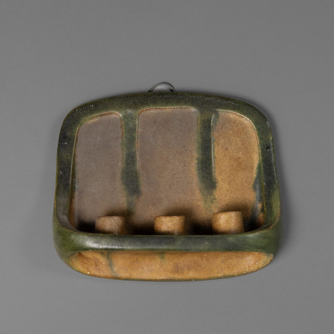 An American art pottery wall sconce: American art pottery wall sconce, circa 1913, end-of-day piece, with matte green and brown color over molded form featuring three candle sockets. The reverse inscribed “Alta Bogart / from her friend