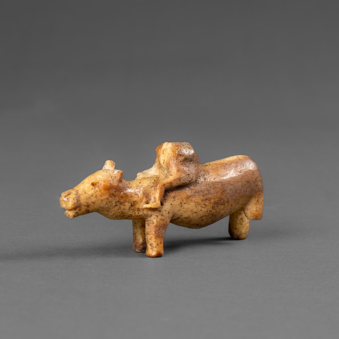 An Eskimo hunting amulet: Alaska, 19th century, or earlier, depicting a human figure (head absent) riding a bear-like animal. The compact form is rendered with lightly defined features and natural surface patina. Lg. 3 in.