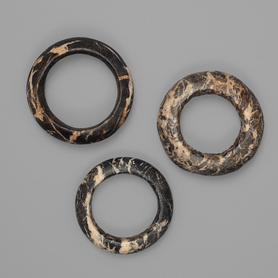 Three stone Dogon bracelets: Mali, 18th-19th century, Mopti region, three stone bracelets made from Hombori Mountain marble. Exterior dia. 4 3/4, wd. 1 ½, exterior dia. 4 3/4, wd. 1 ½, exterior dia. 4 3/8, wd. 1