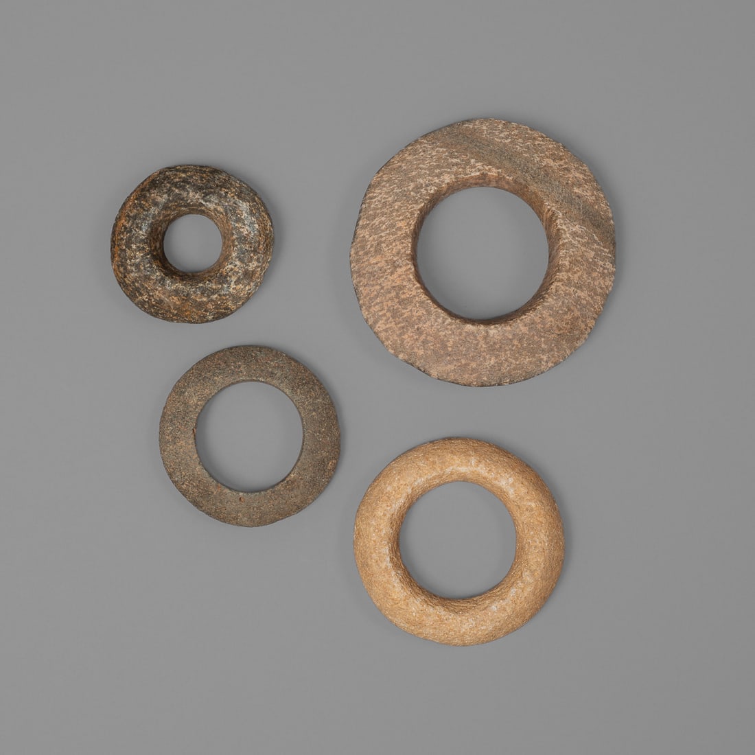 Four Tenere stone bracelets: Niger, Chad, Sudan, ca.5000-2500 BCE, four bracelets carved from diorite stone. Exterior dia. 5, wd. 1 ¼, exterior dia. 3 ¾, wd. ¾, exterior dia. 3 ¼, wd. ½,