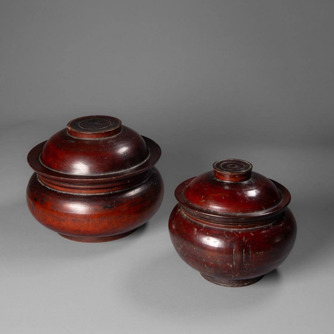 Two Tibetan Tsampa bowls: Early 20th century, Tibetan Turned wood Tsampa bowls each with lid, Tsampa is a roasted Tibetan grain food used widely around the Himalayan region. The loose roasted grain is stored in containers