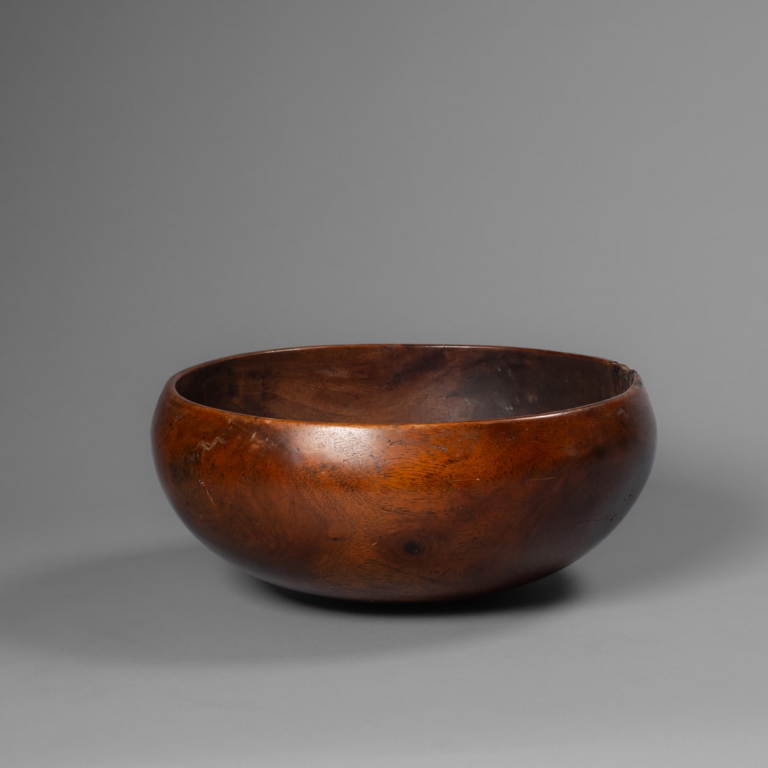 A Hawaiian poi bowl, Umeke la’au puahala: 19th century, probably kou wood, the interior carved out by hand, with a large block repair below the rim with small wood inclusions, and a wood zigzag repair from the rim from the other side, minor