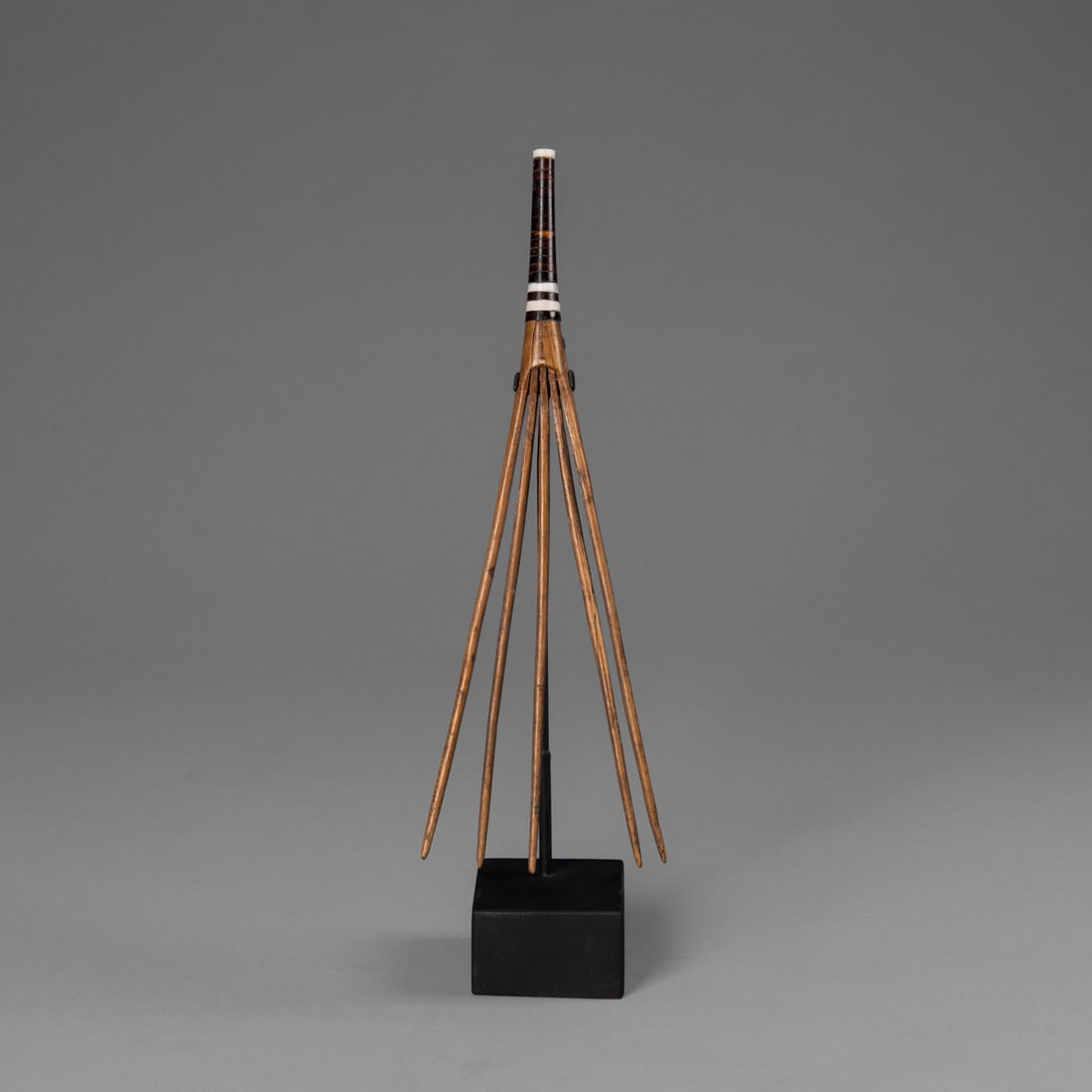 A Micronesian comb: Yap, early 20th century, the five-pronged wood comb with shell disks ay the top, on a custom base. Lg. 9 1/2 in. Provenance: Private Collection, Santa Fe, NM.