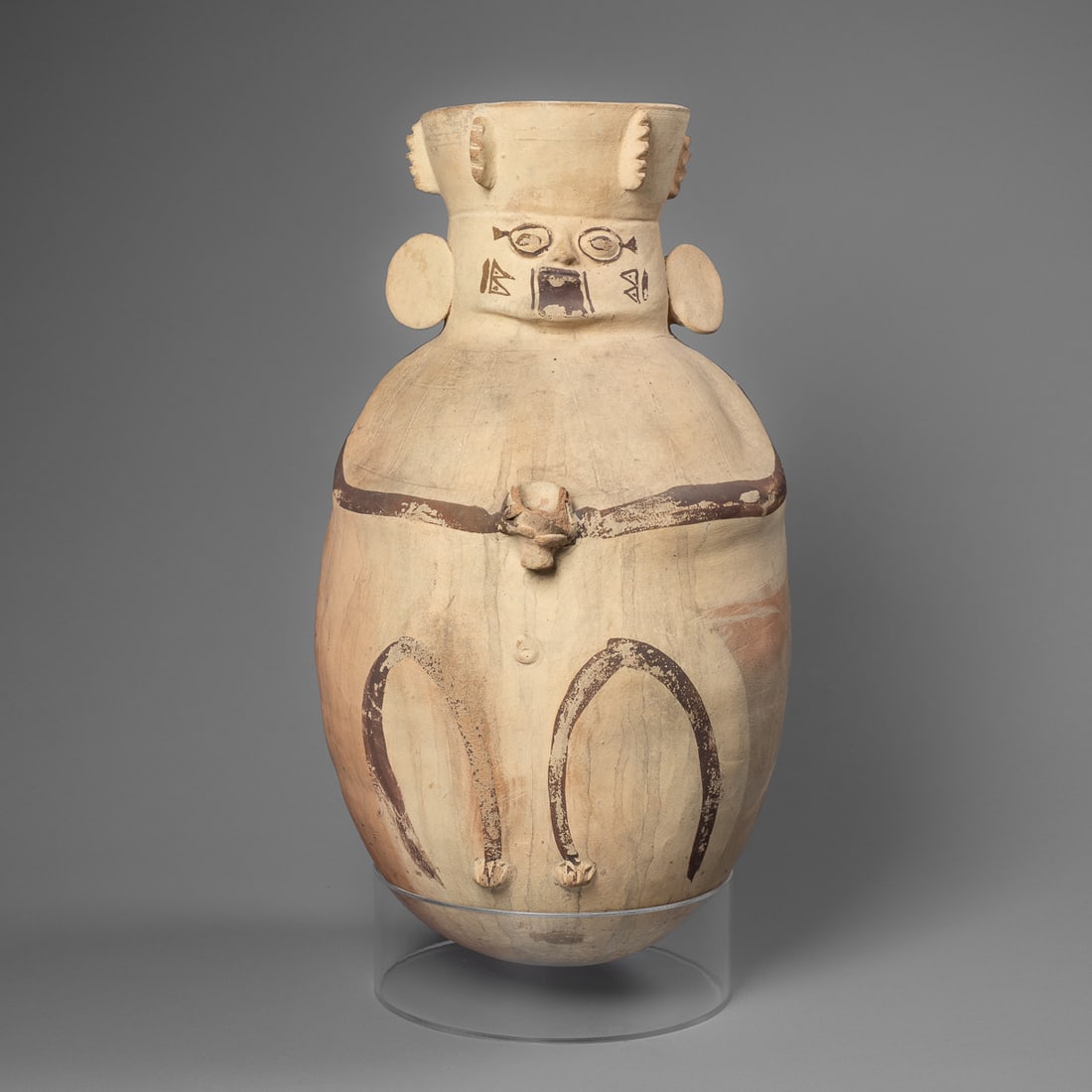 A Pre-Columbian Chancay vessel: Circa 800-1200 CE, Peru, Chancay culture, the bi-chrome earthenware effigy vessel, with figures face with protruding eyes, nose, round ear ornaments, and headdress. The headdress with applied