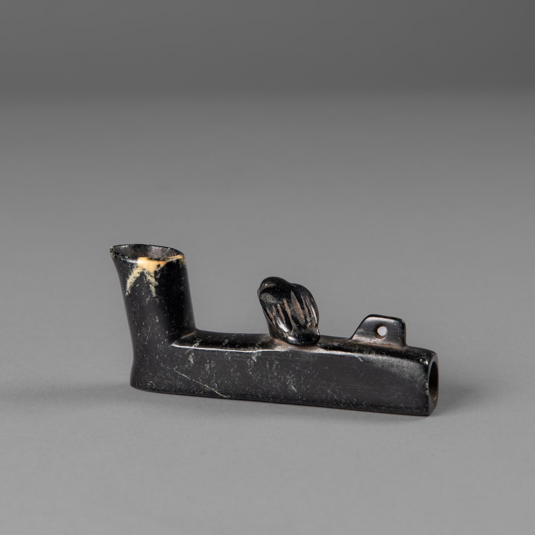 A Cherokee/Creek bird effigy pipe bowl: 18th century, black and yellow polished stone, Lg. 3 1/2 in. Provenance: Private collection, Belle Fourche, South Dakota; The F. J. Hesse collection.