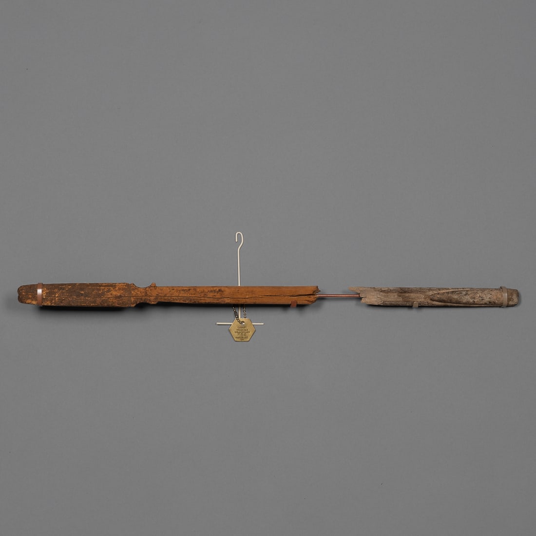 A Prehistoric Southwest atl atl: Pueblo, pre-contact period, the wood spear thrower, broken in two pieces, with custom wall mount. Lg. displayed 20 1/2 in. With brass collection tag marked, "Corrow Artifact Collection, 286 Santa Fe,