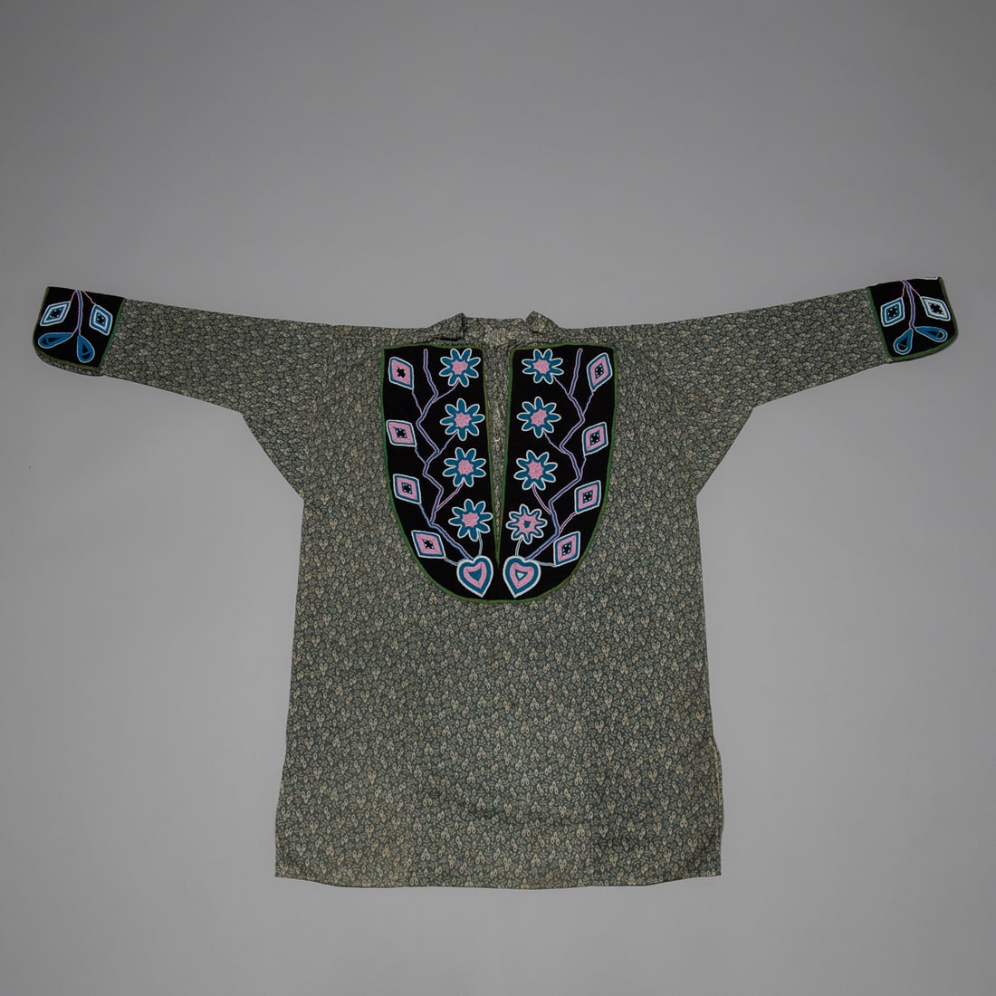 A 19th Century Delaware (Lenape) Beaded Calico Long Shirt & Legging Strips: A 19th century man’s Native American long shirt of printed blue-grey calico trade cloth with an allover small-scale cream leaf motif, tailored in the traditional pullover style with dropped