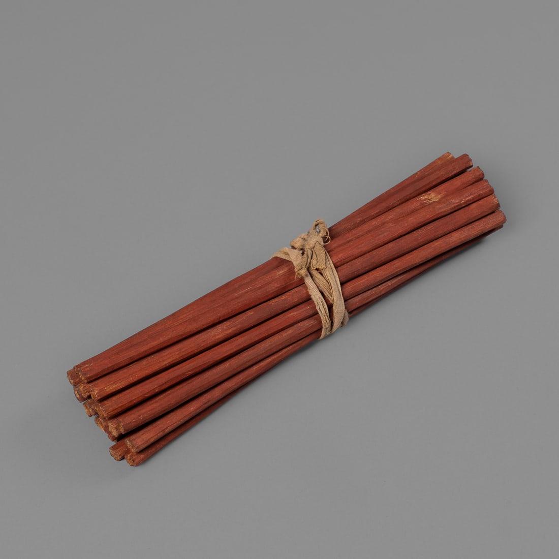 A collection of Chippewa / Ojibwa counting sticks: Circa 1850s, a set of twenty-one counting sticks painted red with cotton cloth binding. Lg. 6 5/8 in. Provenance: The James Pavitt and Carolyn Stettner collection, Santa Fe, NM; Gaylord Torrence,