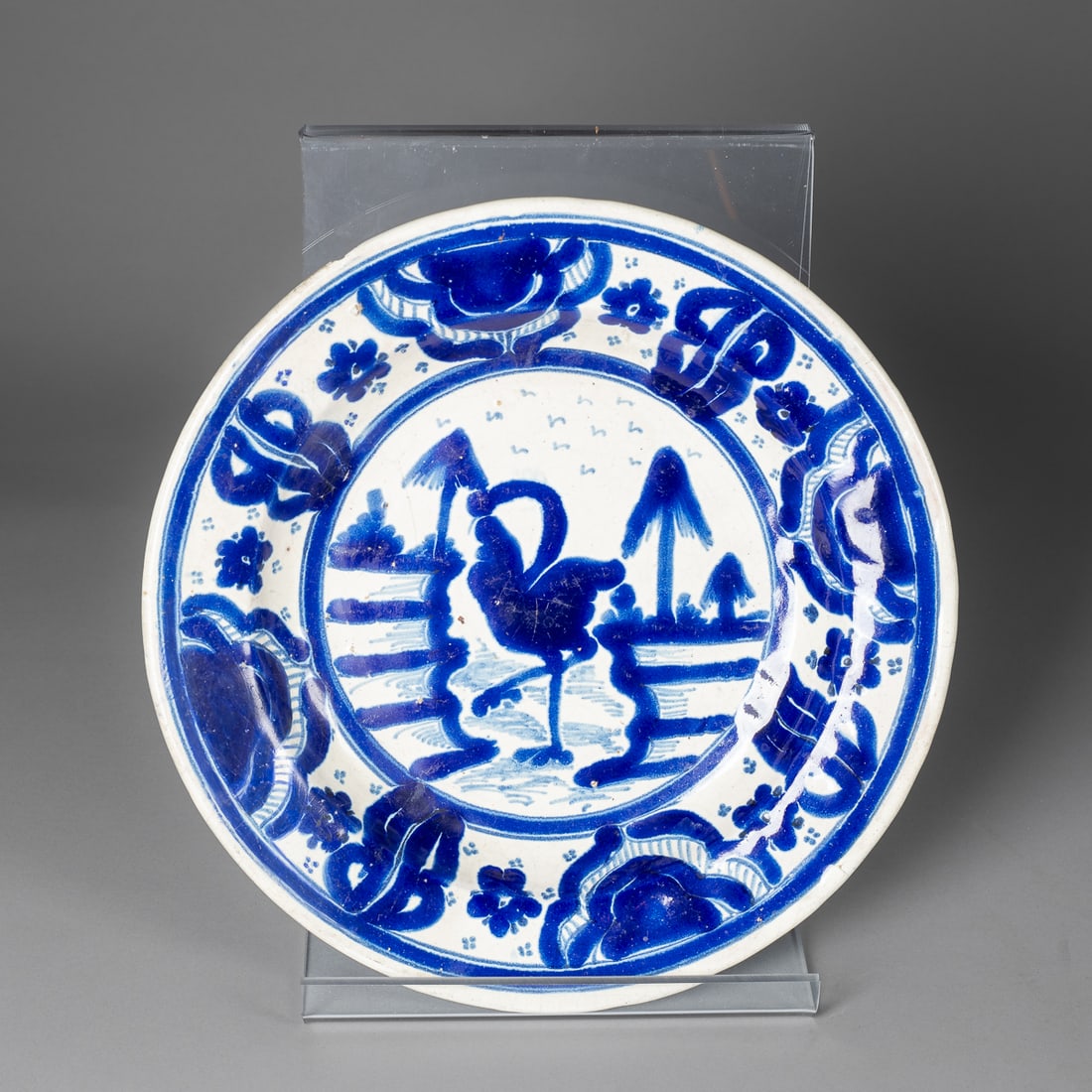 A heavy cobolt Mexican plate: Circa 1900, attributed to Enrique Luis Ventosa, Puebla, the tin-glazed earthenware plate decorated with cobalt colored foliate patterns and an ostrich in a landscape, (minor chip to rim). Dia. 12 1/2