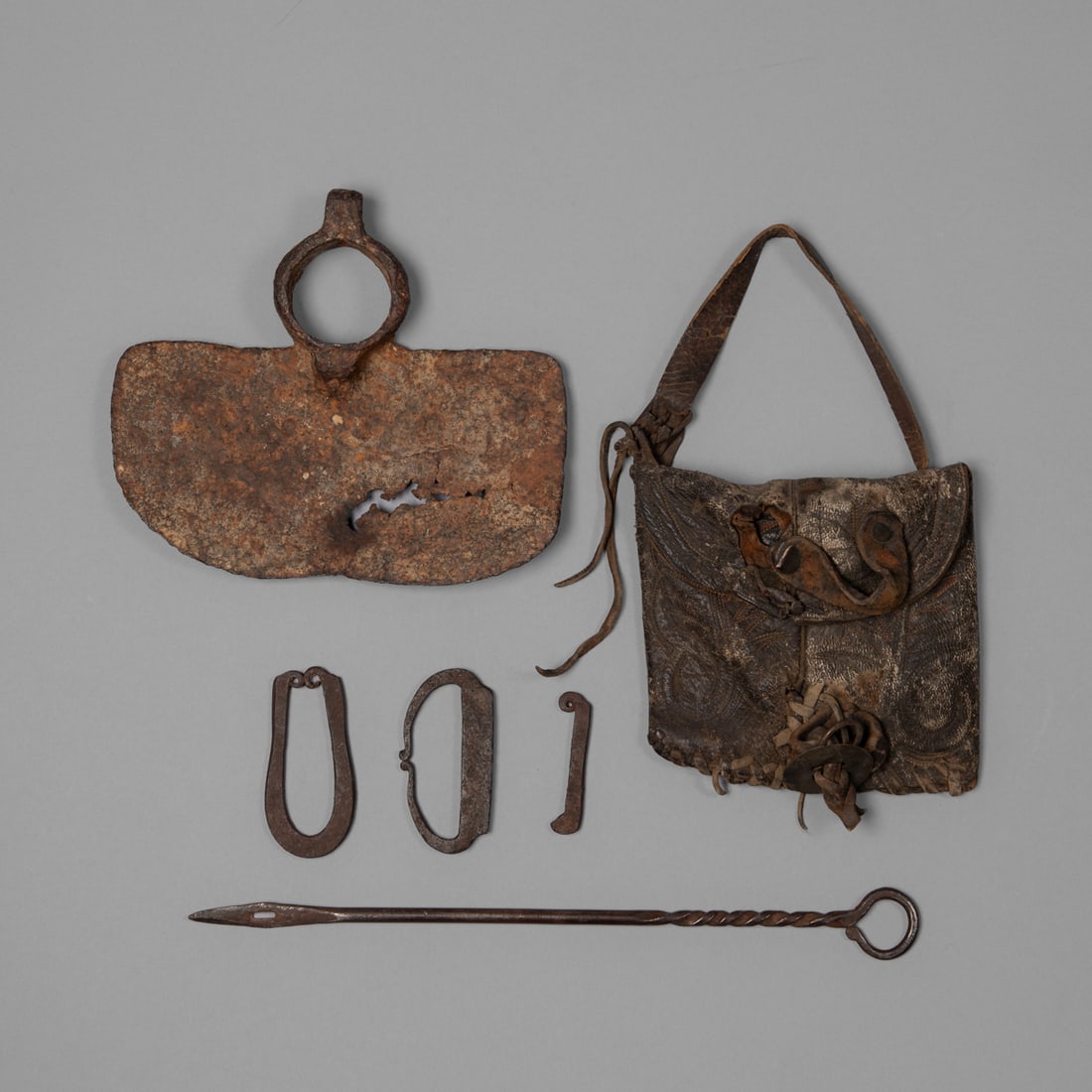 A sheepherder's bag and tools: Fur Trade Era, 19th century, a sheepherder’s bag made from cowboy boot top with flint striker, beaver pelt bailing needle, a farming hoe and two flint strikers, from the Spanish Colonial era. Hoe 6
