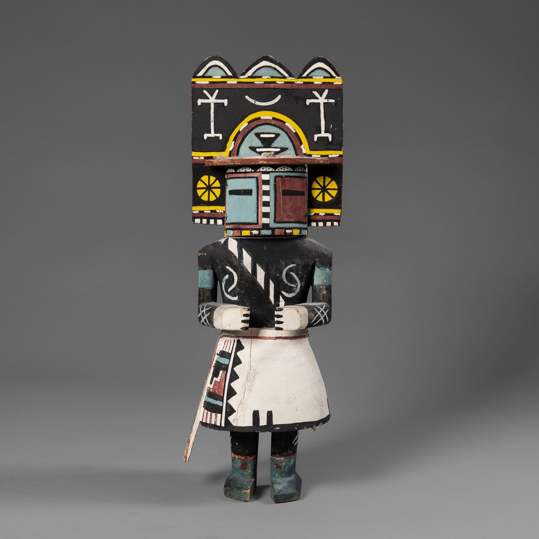 A large Hopi kachina: The large kachina with a ;large painted tableta, black shirt, white kilt with decorated sash. Ht. 16 3/4 in.